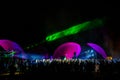 Colorful laser lights shining and moving over dancing crowd during DJ party