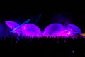 Colorful laser lights shining and moving over dancing crowd during DJ party