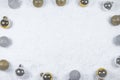 Colorful layout made of Christmas tree silver and gold baubles on snowy background