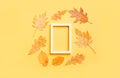 Colorful leaves frame on yellow background with copy space. Halloween or thanksgiving concept