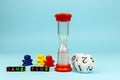 Colorful letter cubes, polihedral dice, colorful figurines and hourglass.