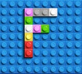 Colorful letter F from building lego bricks on blue lego background. Lego letter M