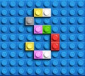 Colorful letter S from building lego bricks on blue lego background. Lego letter M