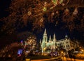 Colorful Light Illuminated Night Christmas Market with crowd motion blurred at the Vienna City Hall at Rathausplatz, Austria