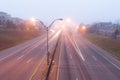 Colorful light traces of busy night traffic on highway. Atlanta city street, foggy autumn weather Royalty Free Stock Photo