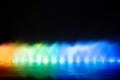 Colorful lights with blurry fountain, water show on black background in city at night Royalty Free Stock Photo