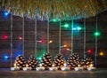 Colorful lights of garlands, fir cones and candles on the background of old barn boards