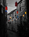 Lights illuminate a narrow alley between buildings Royalty Free Stock Photo