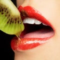 Colorful lips eating kiwi