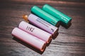 Colorful 18650 Lithium Ion Battery cell on a wooden table known for use with vape or e cigarette. Also used to make laptop battery Royalty Free Stock Photo