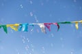 Colorful little Flags Moved by the Wind: Sky in the background and Soap Bubbles in the Air Royalty Free Stock Photo