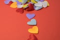 Colorful little hearts are scattered on top of the red background Royalty Free Stock Photo