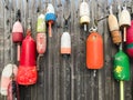 Colorful lobster buoys tied to a wooden fence in a fishing village in Maine, USA Royalty Free Stock Photo