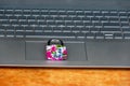 Colorful locked padlock on the mouse pad of a laptop computer, security concept with feminine touch Royalty Free Stock Photo