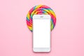 Colorful lolipop and mobile phone on pink background, techology and children sweets