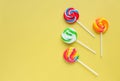 Colorful lollipops, different colored round candy on sticks on yellow background. Royalty Free Stock Photo