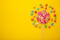 Colorful lollipops and different colored round candy on yellow background Royalty Free Stock Photo