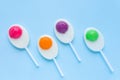 Colorful lollipops, duck egg shaped candies on sticks on light blue background. Flat lay, Royalty Free Stock Photo
