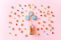 Colorful lollipops swirls on sticks in glass bottle. Striped spiral multicolored candy on pink background, top view Royalty Free Stock Photo