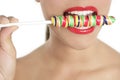 Colorful Lollypop in perfect woman teeth Royalty Free Stock Photo
