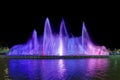 Colorful luminous and musical fountain. Night view. Multicolored streams of water are blurred against a black sky