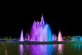 Colorful luminous and musical fountain. Night view. Multicolored streams of water are blurred against a black sky