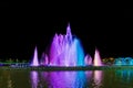 Luminous and musical fountain. Night view. Multicolored streams of water are blurred against a black sky