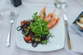 Colorful lunch plate with prawn and salad served at a fancy restaurant in Portofino, Italy