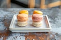 Colorful macaron cookies displayed on square plate stand attractively
