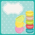 Colorful macaron cookies and teacup on blue background