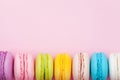 Colorful macaron or macaroon on pink pastel background top view. Flat lay composition.