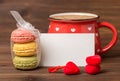 Colorful macarons cake tied ribbon, cup of coffee, empty blank