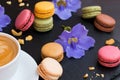 Colorful macarons cakes with cup of coffee. Sweet and colorful french macaroons. Royalty Free Stock Photo