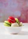 Colorful macarons cookies in white bowl on pastel background, copy space Royalty Free Stock Photo