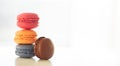 Colorful macarons pile on white background, close up view