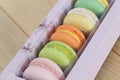 Colorful Macaroons boxset on wooden background.