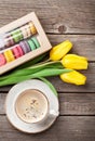 Colorful macaroons, coffee cup and yellow tulips Royalty Free Stock Photo