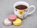 Colorful macaroons with cup of tea