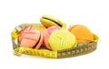 Colorful macaroons with measuring tape on white