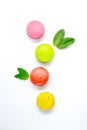 Colorful Macaroons with peppermint leaves on white background.