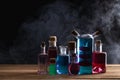 Colorful magic potion bottles on wooden table. Medieval alchemist laboratory with various kind of flasks.