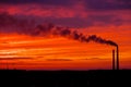 Colorful Magic Sunset. Roofs of city houses during sunrise. Dark smoke coming from the thermal power plant pipe Royalty Free Stock Photo