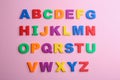 Colorful magnetic letters on pink background. Alphabetical order Royalty Free Stock Photo