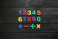 Colorful magnetic numbers and math symbols on wooden background, flat lay Royalty Free Stock Photo