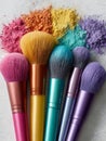 Colorful makeup brushes with vibrant powder on a surface. Royalty Free Stock Photo