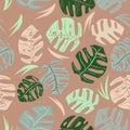 colorful manstera leaves pattern on brown background