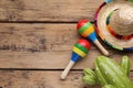 Colorful maracas, toy cactus and sombrero hat on wooden table, flat lay with space for text. Musical instrument Royalty Free Stock Photo