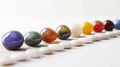 Colorful marbles arranged in a line on a striped surface, displaying a variety of hues and reflections Royalty Free Stock Photo