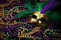 Colorful Mardi Gras beads and mask on festive carnival background Royalty Free Stock Photo