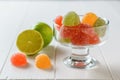 Colorful marmalade in a glass bowl and lime on a white rustic wooden table Royalty Free Stock Photo